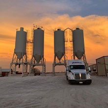 Silos de almacenamiento al atardecer con tractocamión Delsa